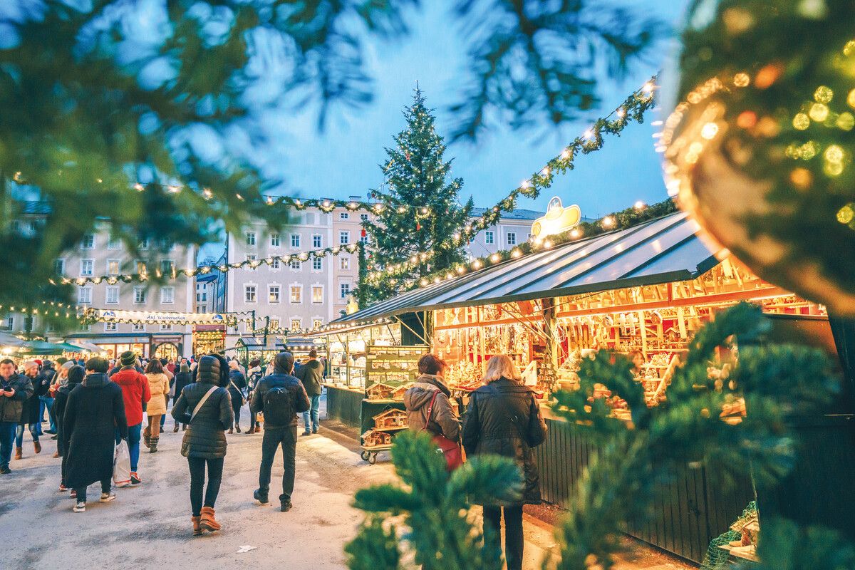 Lichterglanz und geschäftiges Treiben auf dem Salzburger Christkindlmarkt am Dom- und Residenzplatz. Shutterstock