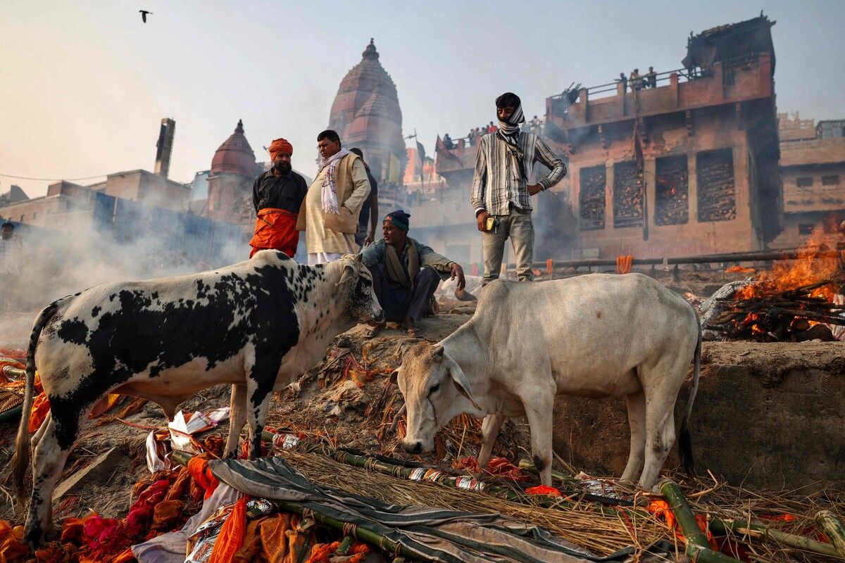 Verwandte eines Verstorbenen versammeln sich zu einem Bestattungsritus am Ufer des Ganges in Varanasi in Indien.