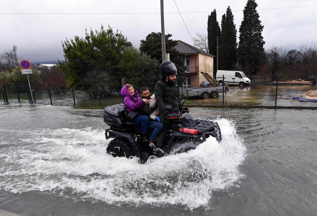 Ein Quadfahrer bringt eine Familie durch das durch heftige Regenfälle überflutete Danilovgrad in Bosnien.