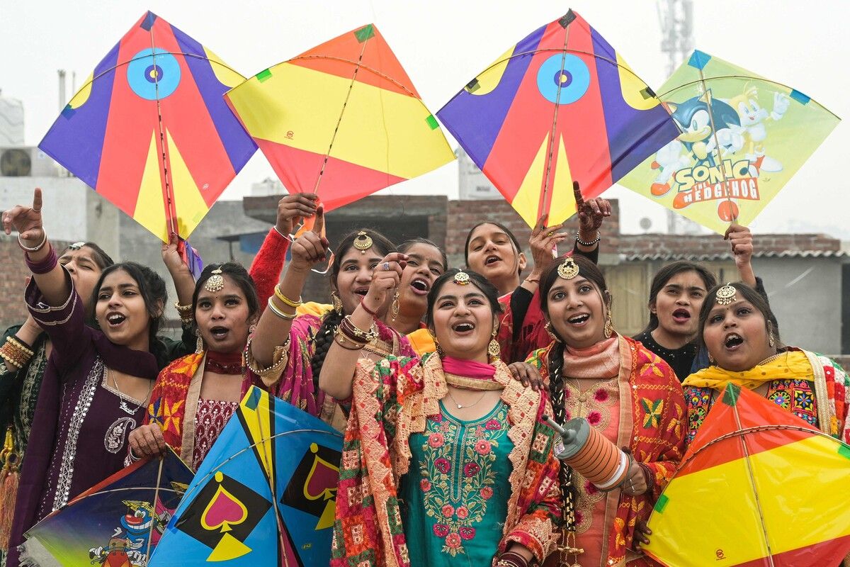 Frauen lassen in Amritsar in Indien vor den Erntefesten Makar Sankranti und Lohri bunte Drachen steigen. AFP (5)