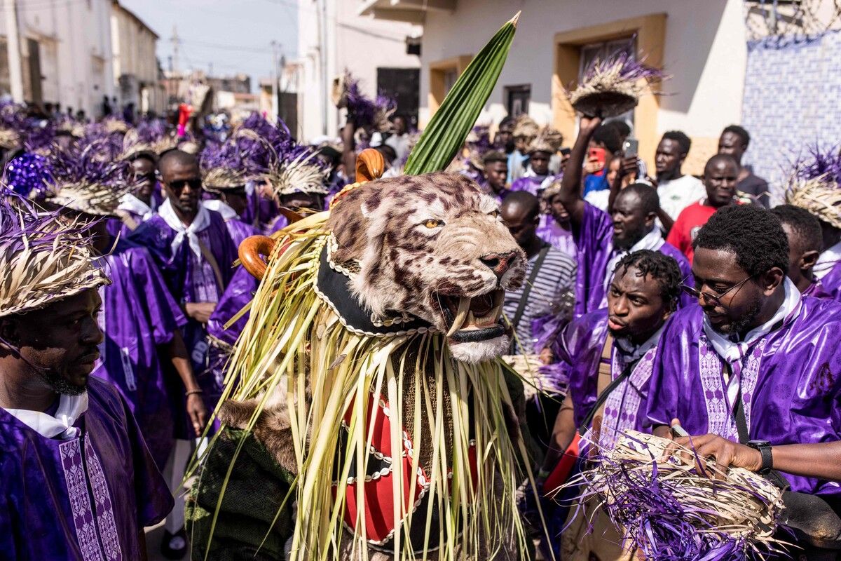 Mitglieder der Jagdgesellschaft „Odilleh“ tragen beim jährlichen Neujahrsjagdfestivals in Banjul in Gambia einen präparierten Tigerkopf durch die Straßen. Das tief in der Tradition verwurzelte Festival hat sich zu einer beliebten Neujahrsfeier entwickelt.