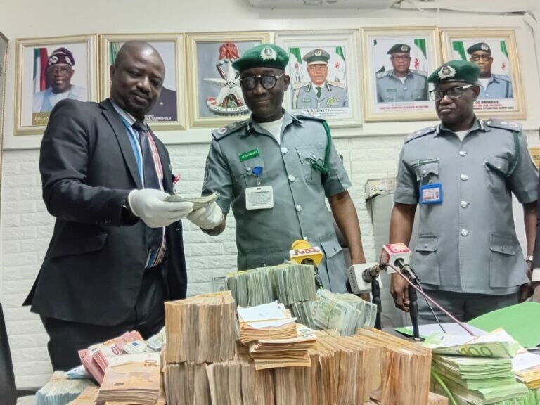 Nigerianische Behördenvertreter mit dem beschlagnahmten Bargeld. ⇒ncs