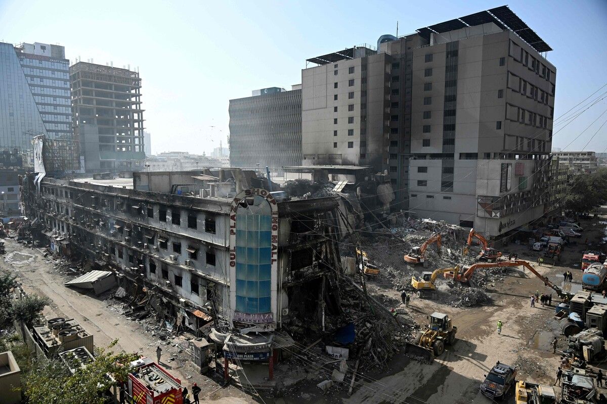 Rettungskräfte räumen Trümmer in einem ausgebrannten Einkaufszentrum in Karachi, nach­dem ein verheerendes Feuer mindestens 67 Menschen das Leben kostete.⇒afp