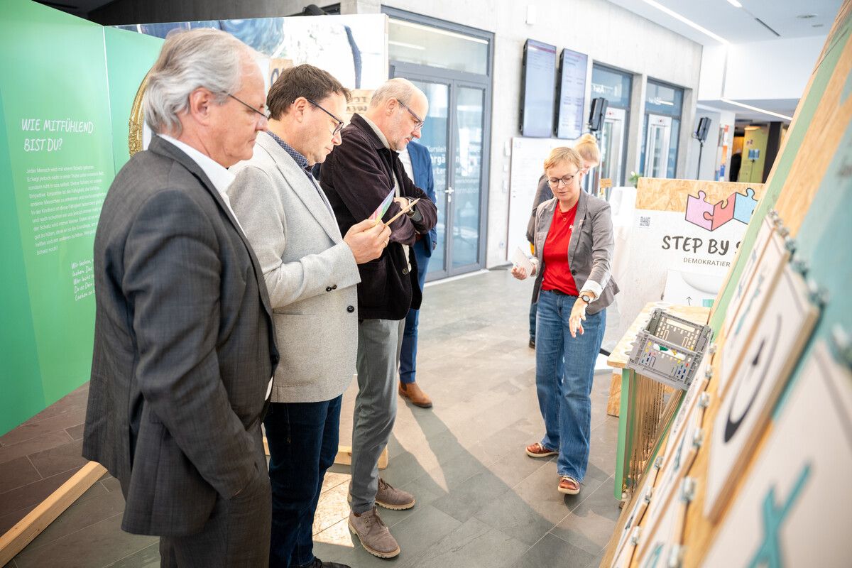 Sabine Klapf präsentiert Landtagspräsident Harald Sonderegger, Stefan Fischnaller (VHS Götzis) und Edgar Mayrhofer (BORG Götzis) die Stationen.⇒AK Vorarlberg