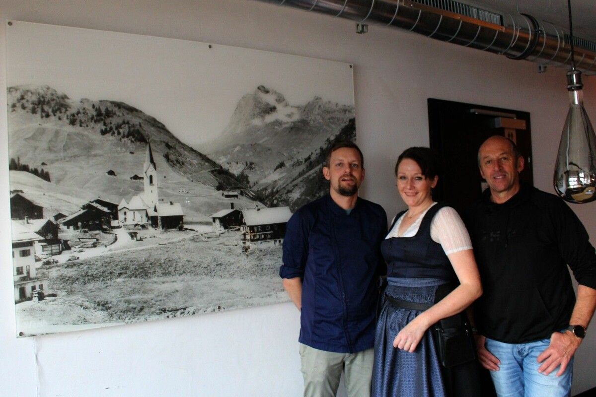 Stolz präsentieren Bürgermeister Stefan Strolz und die neuen Pächter Marina und Michel Niesporek das große Poster, das Auskunft über die Entwicklung von Warth gibt. ⇒stp (3)