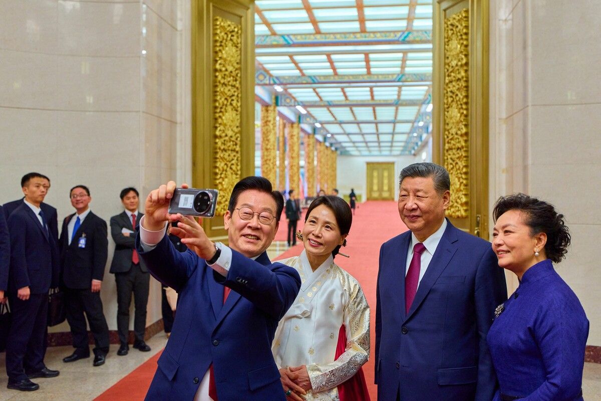 Südkoreas Präsident Lee Jae Myung (l.) und seine Frau Kim Hea Kyung machen nach einem Abendessen in der Großen Halle des Volkes in Peking ein Selfie mit Chinas Präsident Xi Jinping (r.) und seiner Frau Peng Liyuan.