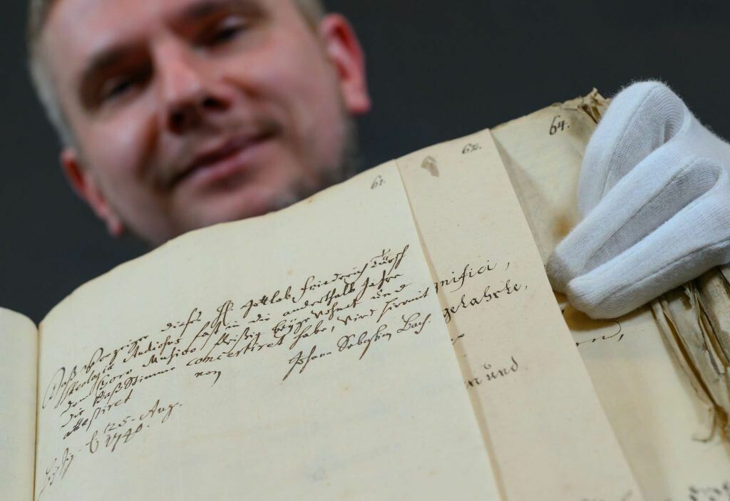 Bernd Koska präsentiert im Stadtarchiv Leipzig eine Handschrift von Johann Sebastian Bach.⇒ APA/dpa/Hendrik Schmidt