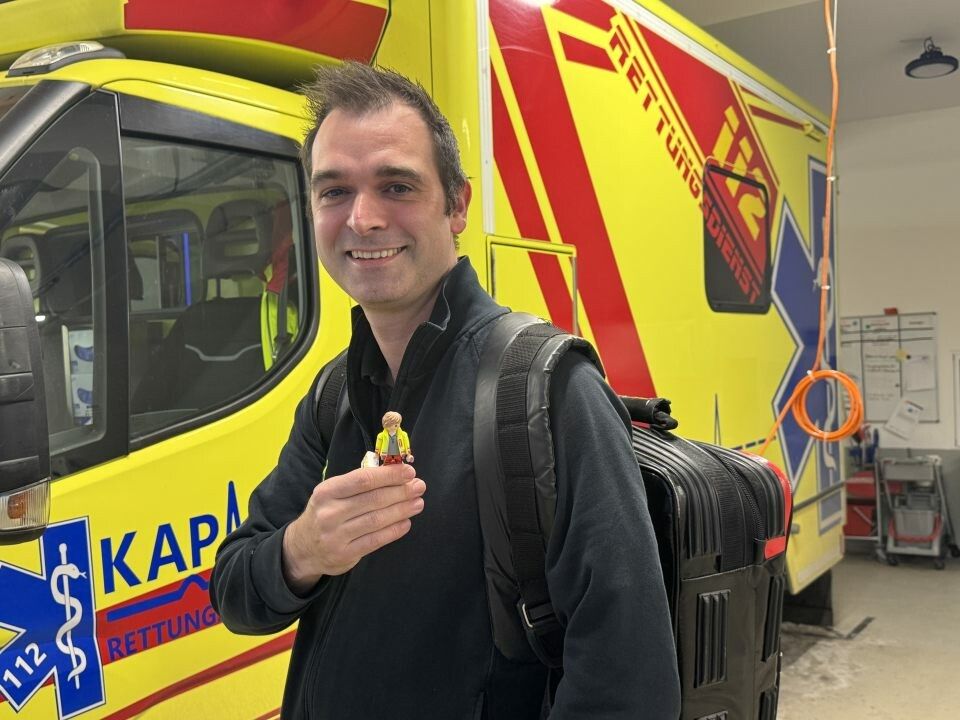 Der Playmobilsanitäter dient hier als Metapher, da der kleine Sanitäter einen riesen Rucksack stemmen muss, mit fehlenden Mitteln.