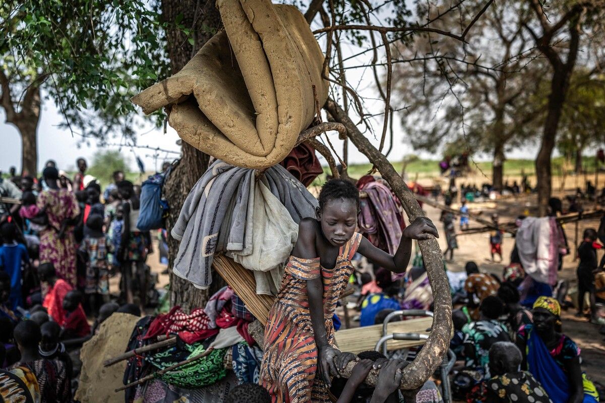 Ein Mädchen aus der Dinka-Gemeinschaft sitzt auf einem Ast, an dem Menschen ihre Habseligkeiten aufgehängt haben. Vertriebene ohne Hilfe oder Unterkunft harren in dem informellen Lager nahe Mingkaman im Südsudan aus. AFP (5)