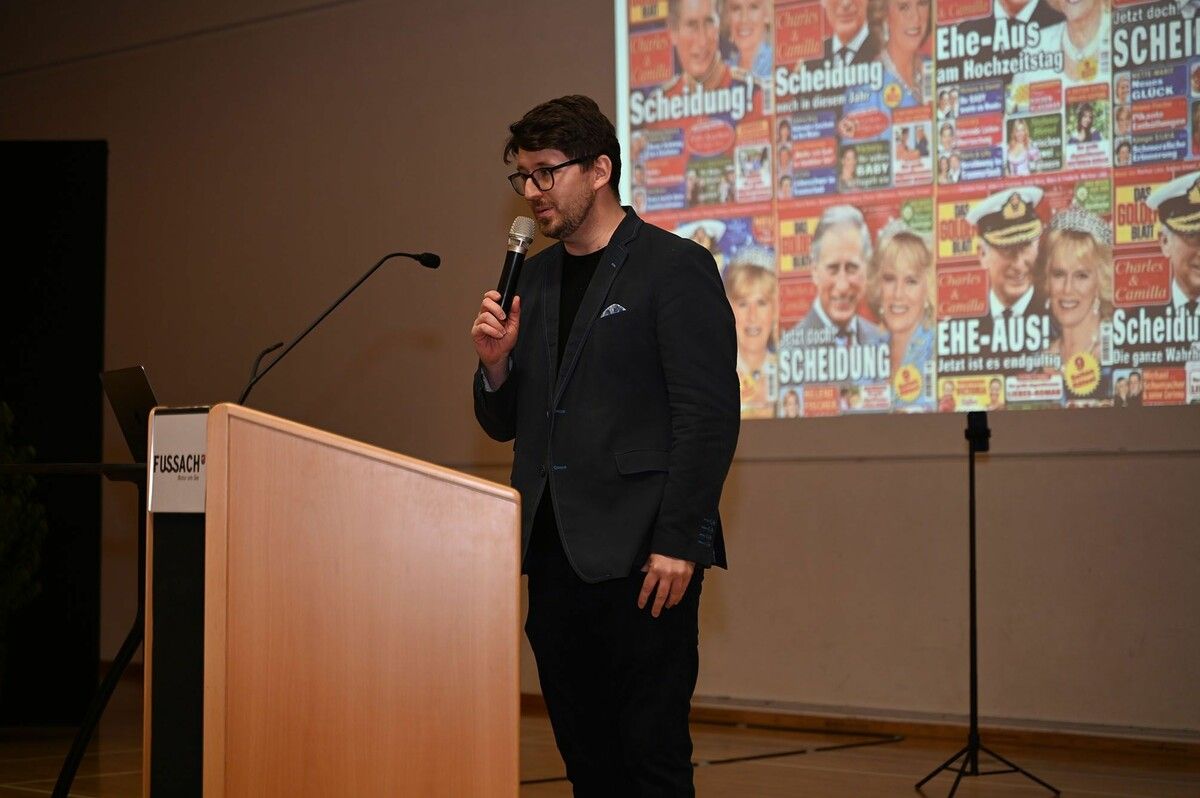 Referent Markus Feigl vor Titelseiten der Regenbogenpresse. ⇒Andrea Fritz-Pinggera
