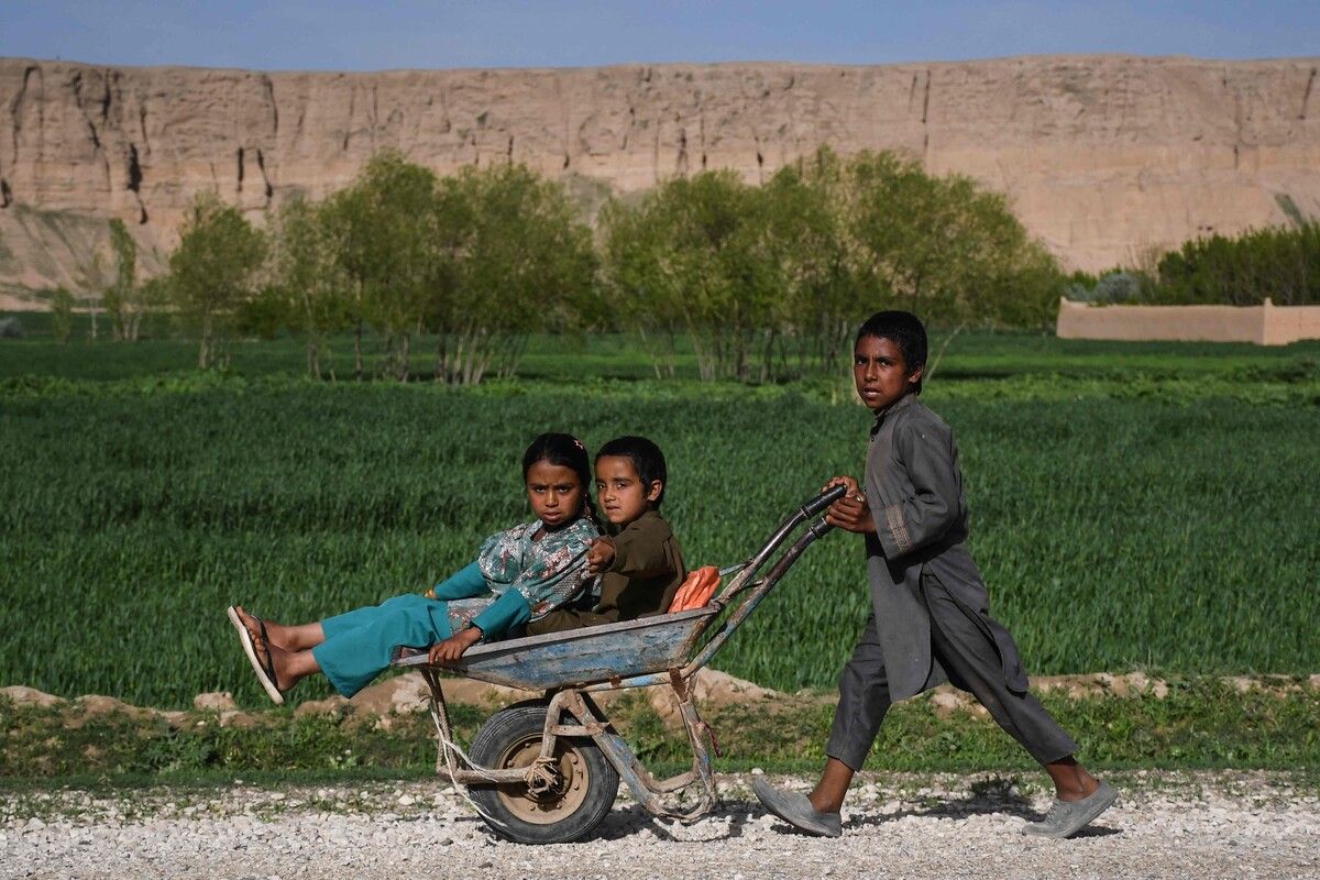 Afghanische Kinder fahren mit einer Schubkarre am Straßenrand in der Provinz Balkh.