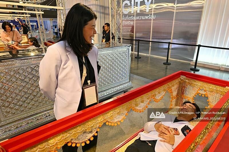 Ein Messebesucher in Nonthaburi testet einen Sarg. Das „Todesfest“ soll zur Auseinandersetzung mit dem Tod anregen.⇒APA-Images/AP/K. Rodsupan