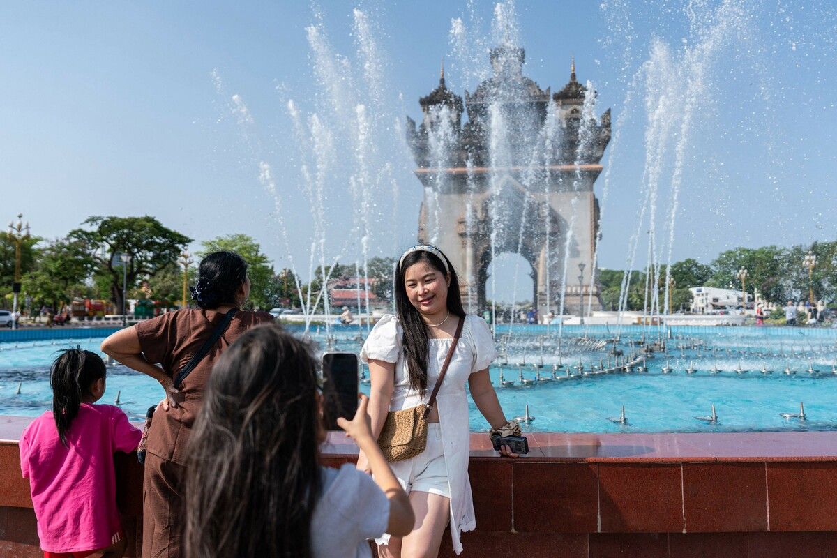 Eine Frau posiert für ein Foto vor dem Patuxai, auch bekannt als Siegesdenkmal, in Vientiane, Laos. AFP (5)