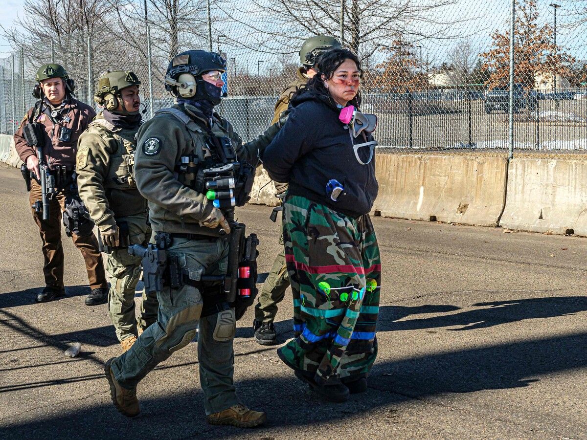 Eine indigene Aktivistin wird in Minneapolis vor einem Bundesgebäude bei Protesten gegen ICE festgenommen.