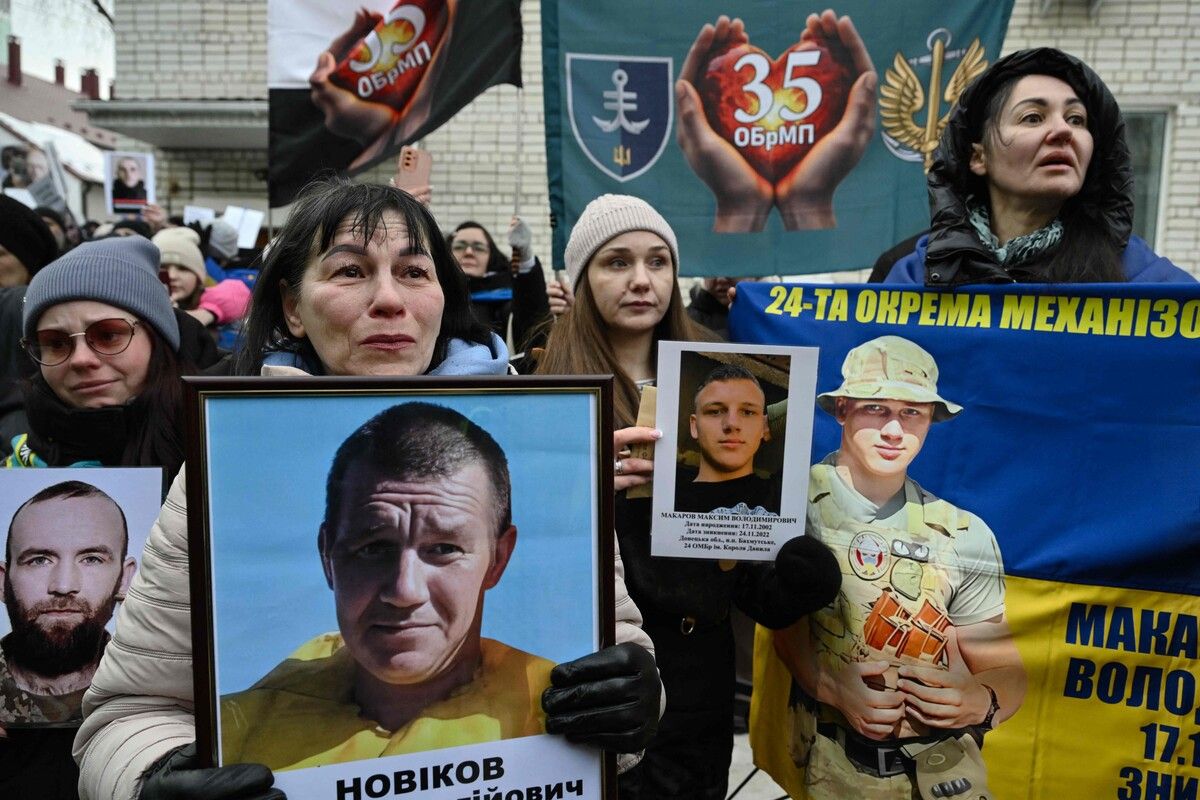 Frauen halten Porträts ihrer vermissten Angehörigen in den Händen, als ukrainische Kriegsgefangene nach einem Gefangenenaustausch in der Region Tschernihiw in der Ukraine eintreffen. AFP (5)