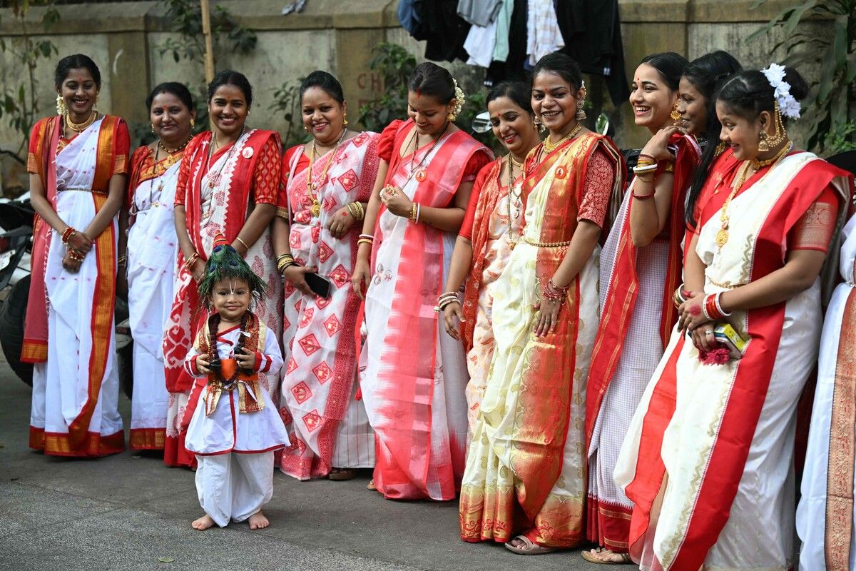 Frauen in traditioneller Tracht beobachten ein Kind, das während der Prozession zu ‚Gudi Padwa‘ tanzt – dem Frühlingsfest, mit dem in Mumbai das neue Jahr gefeiert wird.