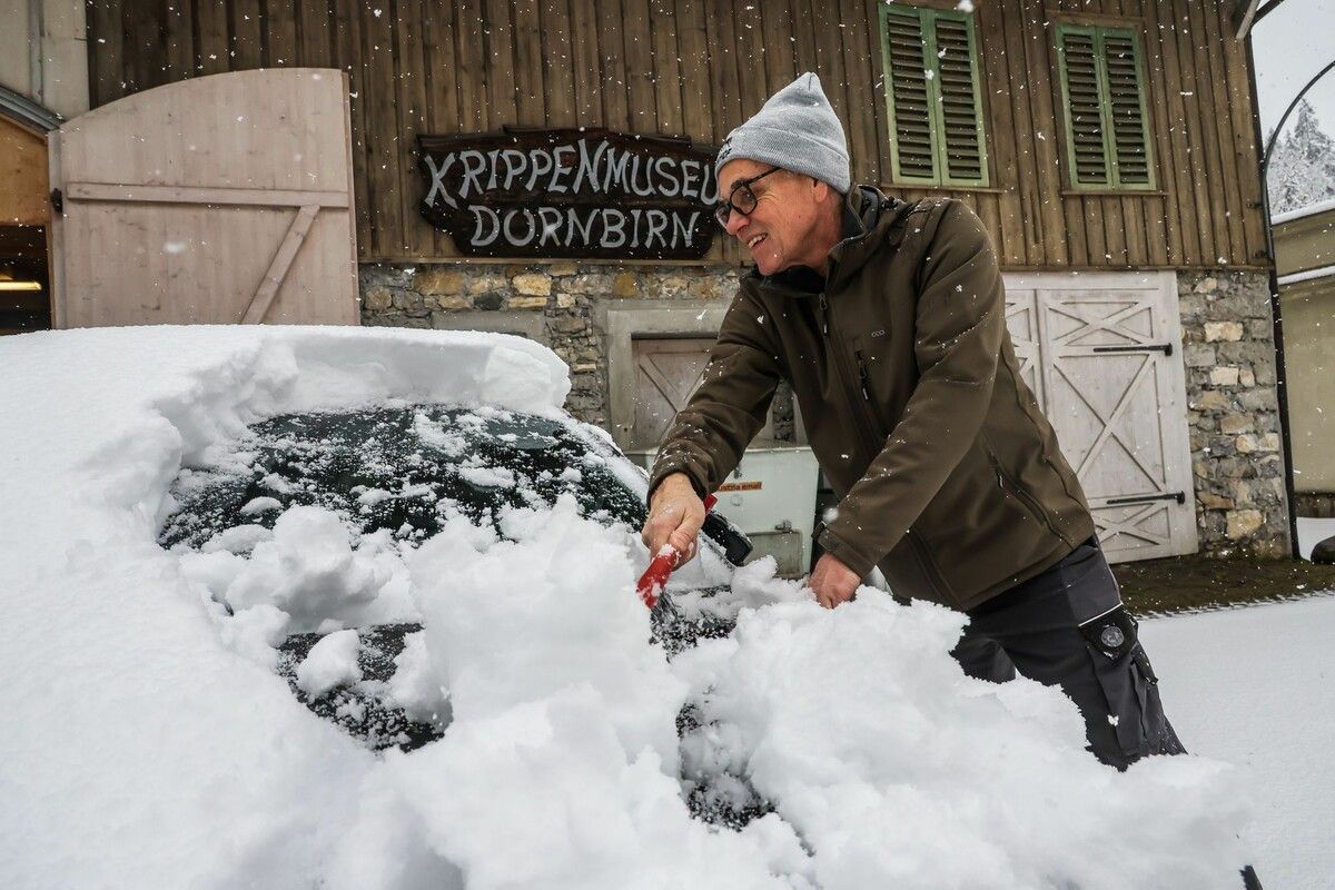 Kurt aus Lustenau muss vor dem Krippenmuseum sein Auto freischaufeln.⇒vn/Steurer