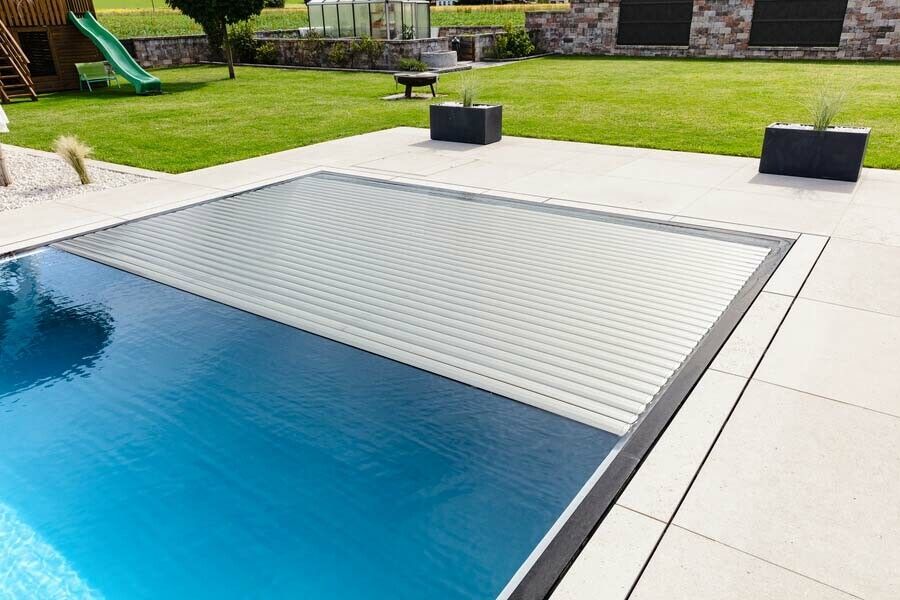 Eine Lamellenabdeckung mit schwimmenden Lamellen, die sich per Knopfdruck automatisch über die Wasseroberfläche schließen, sind der Klassiker. ⇒