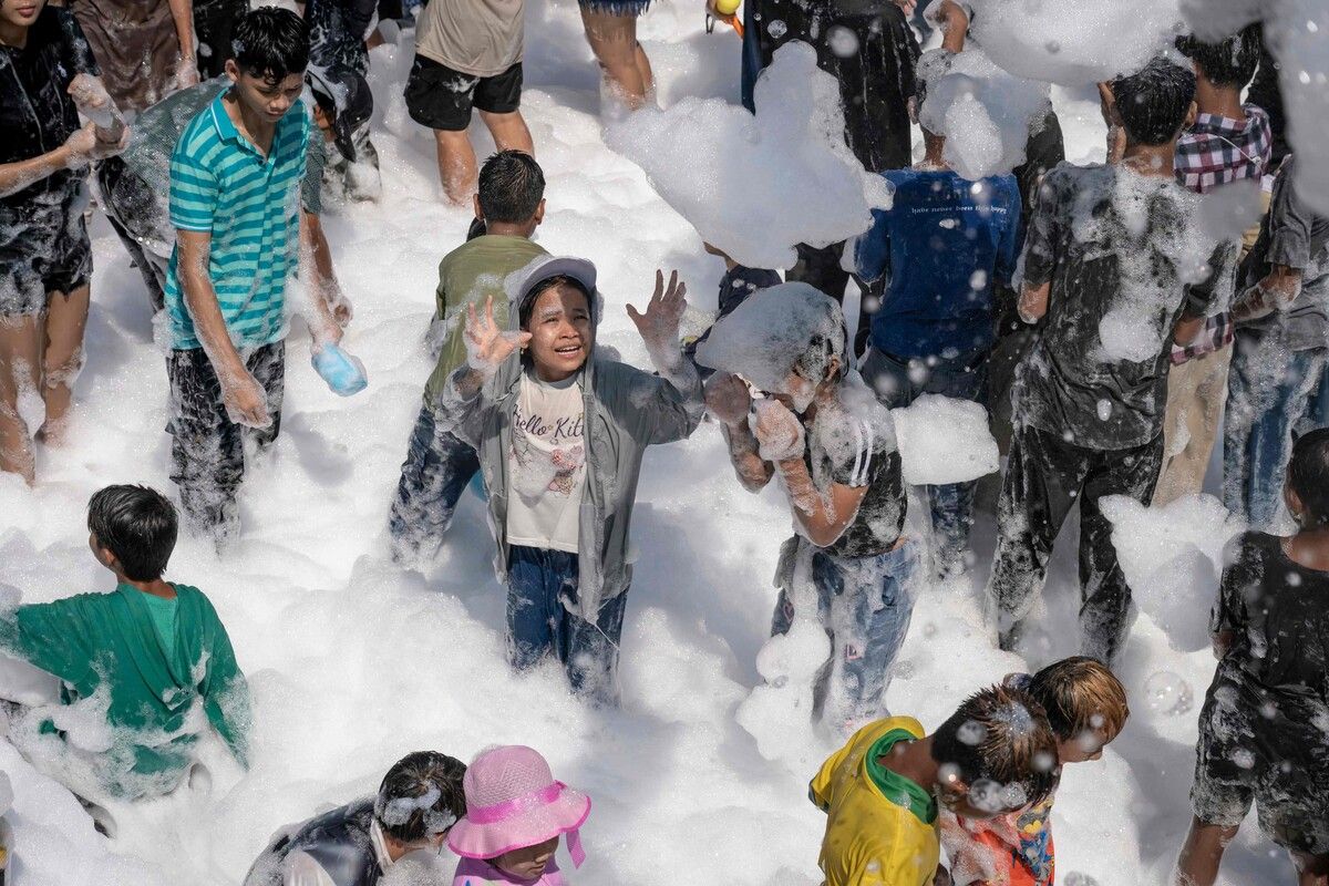 Menschen spielen mit Seifenschaum beim buddhistischen Neujahrs-Wasserfest Thingyan in Yangon, Myanmar.