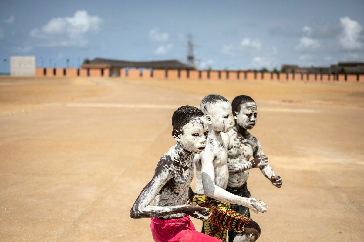 Mit weißem Staub bedeckte Kinder posieren für ein Foto in der Nähe des Denkmals „Tür ohne Wiederkehr“ in Ouidah. AFP (5)
