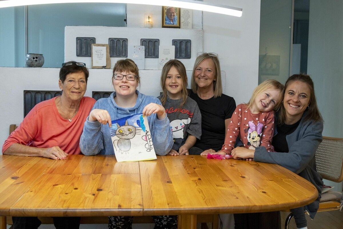 Stolz zeigt Anna im Schoß ihrer Familie ihr aktuellstes Bild. Die mehrfach gehandicapte 32-Jährige ist glücklich mit der neuen Dusche. ⇒VN/Paulitsch