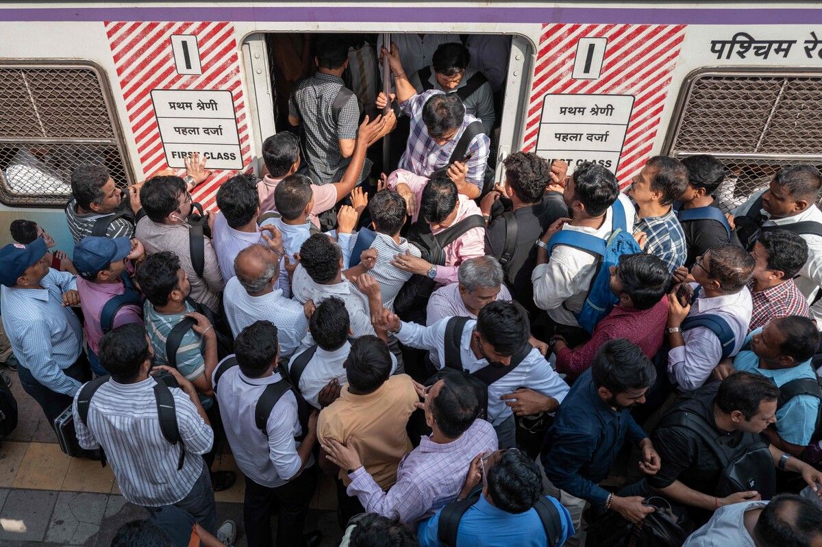 Pendler drängen sich am Bahnhof Dadar in Mumbai, um einen komplett überfüllten Zug zu besteigen.