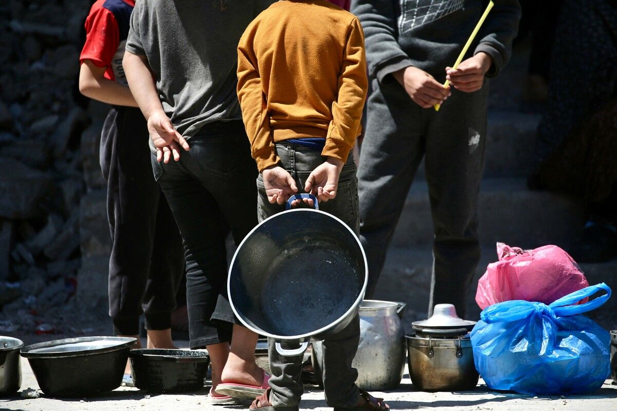 Vertriebene Palästinenser stehen im Flüchtlingslager Bureij für Nahrungsmittel an