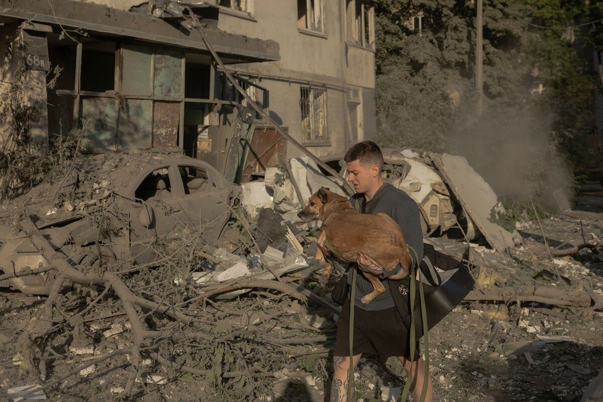 Ein Mann rettet einen Hund aus den Trümmern vor einem Wohnhaus in Kiew, das nach russischen Raketen- und Drohnenangriffen zerstört wurde.⇒AFP