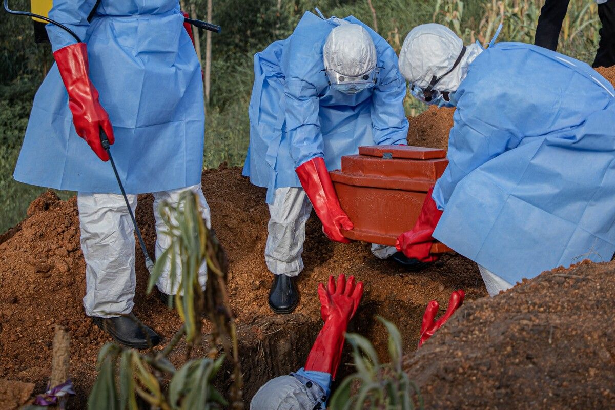 Freiwillige heben den Sarg eines 3-jährigen Kindes, das vermutlich am Ebola-Virus gestorben ist, auf einem Friedhof in Bunia im Kongo.